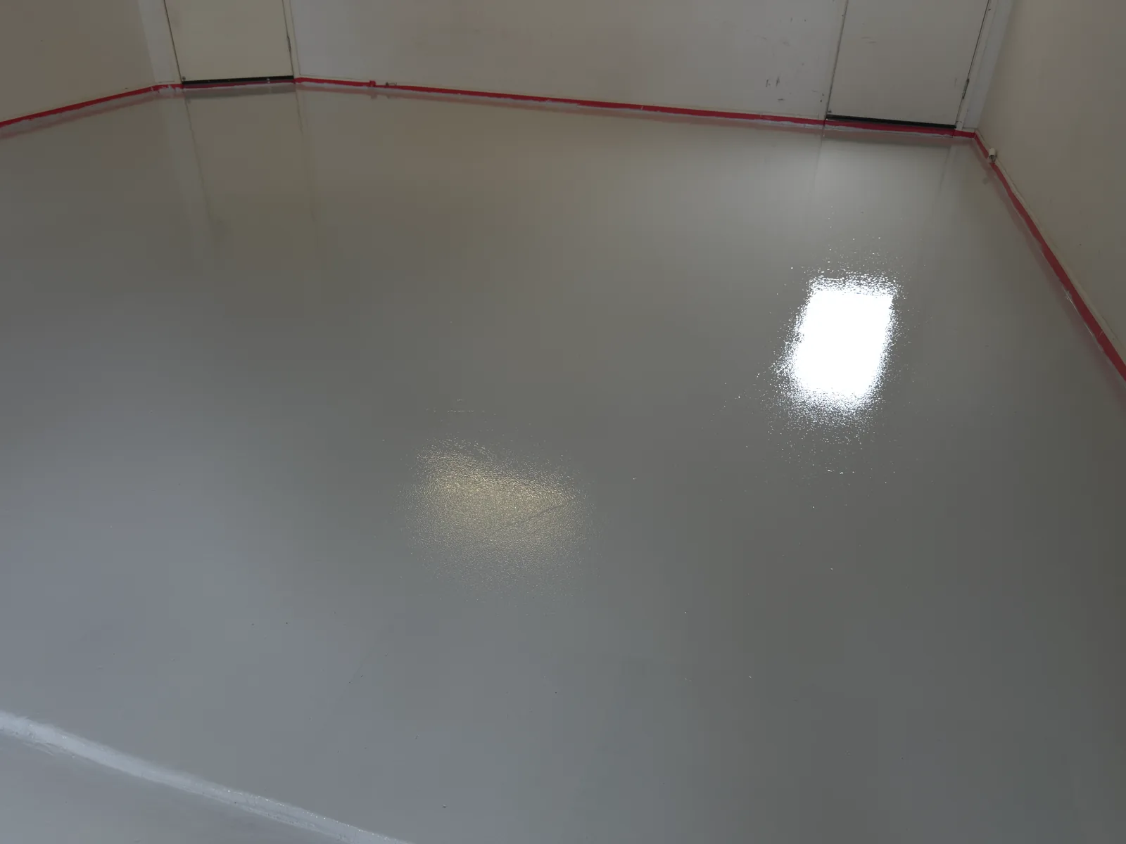 Same room after diamond grinding and a high-gloss solid-grey epoxy coating, Perth